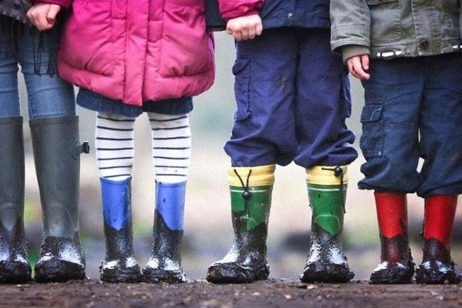Row of children wearing muddy gumboots