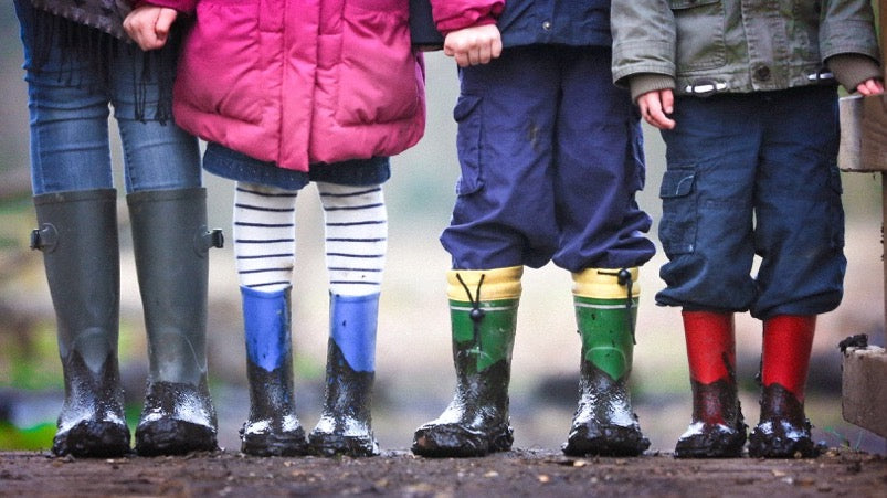 Row of children wearing muddy gumboots