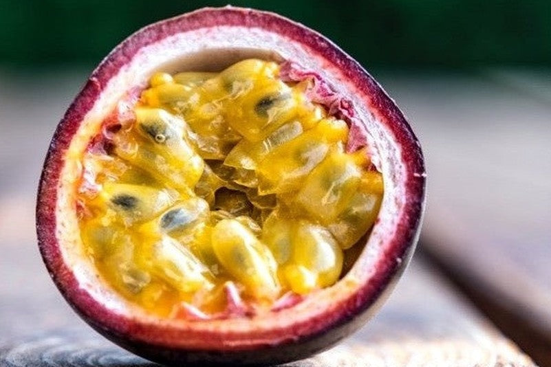 Passionfruit cut in half on wooden bench