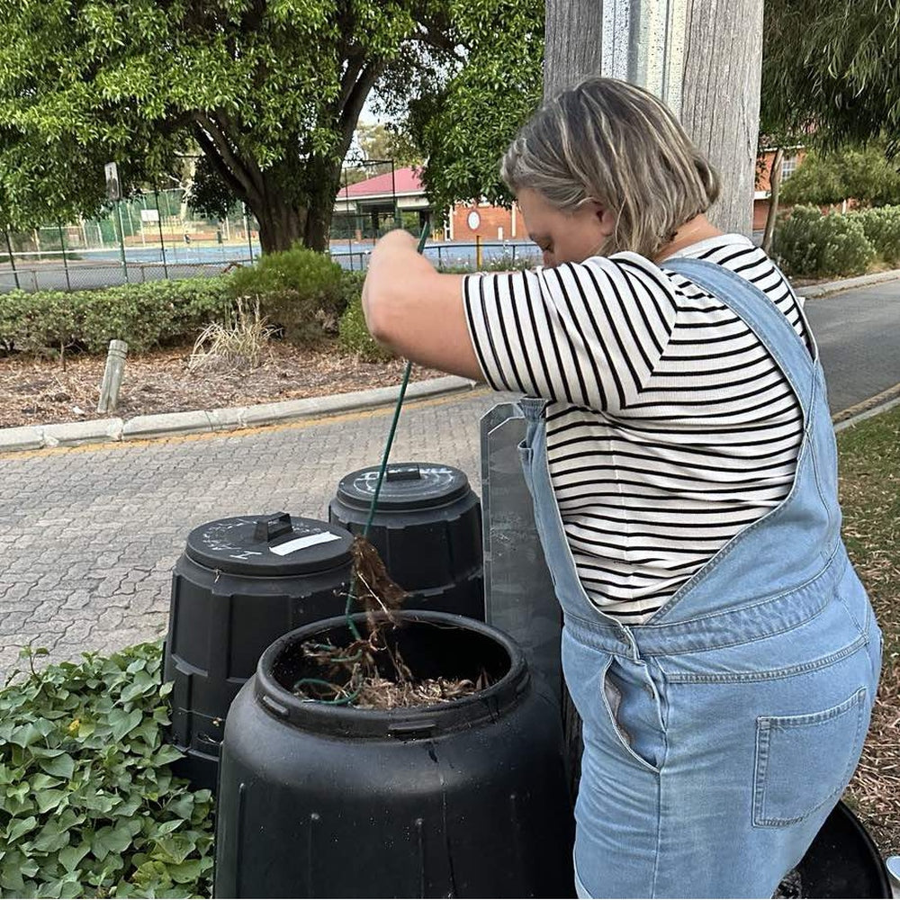 Lady using Compost Mate to aerate compost bin