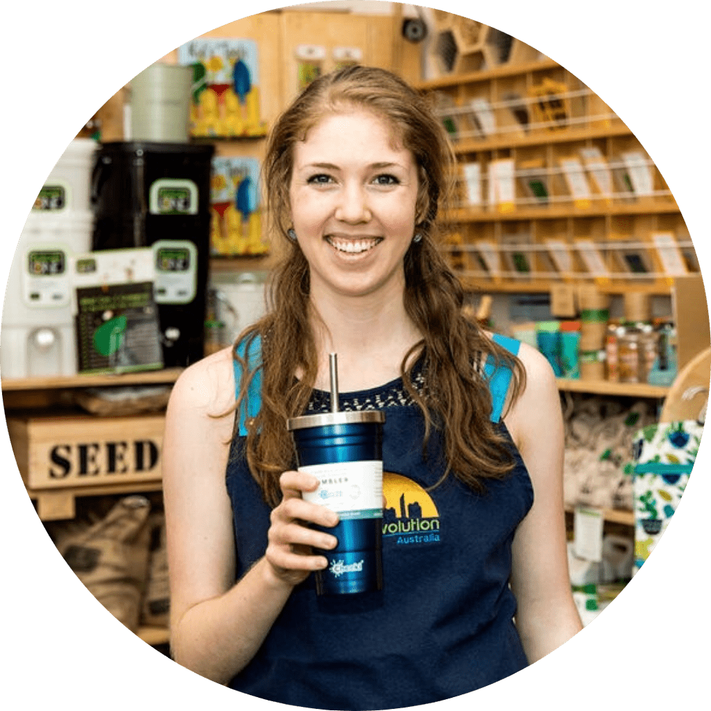 Dana from Urban Revolution in her apron holding a blue stainless steel smoothie tumbler
