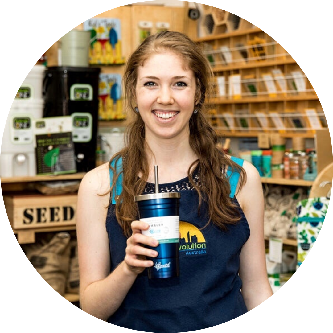 Dana from Urban Revolution in her apron holding a blue stainless steel smoothie tumbler