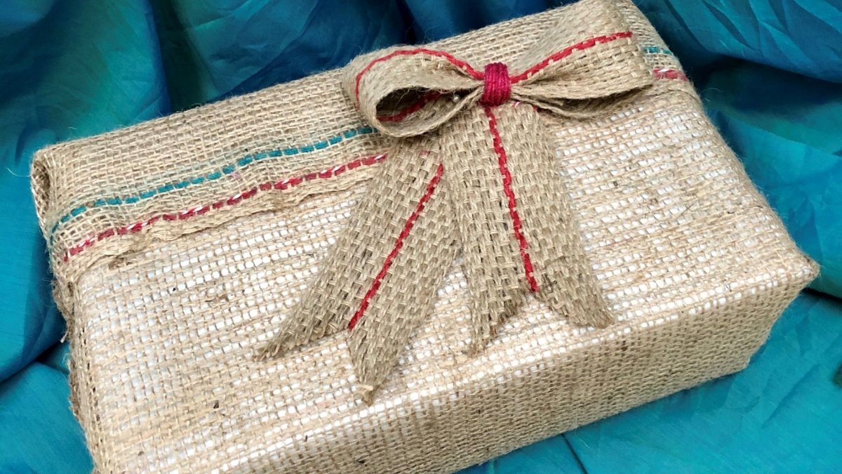 Gift wrapped with compostable materials, including hessian burlap and a jute bow.