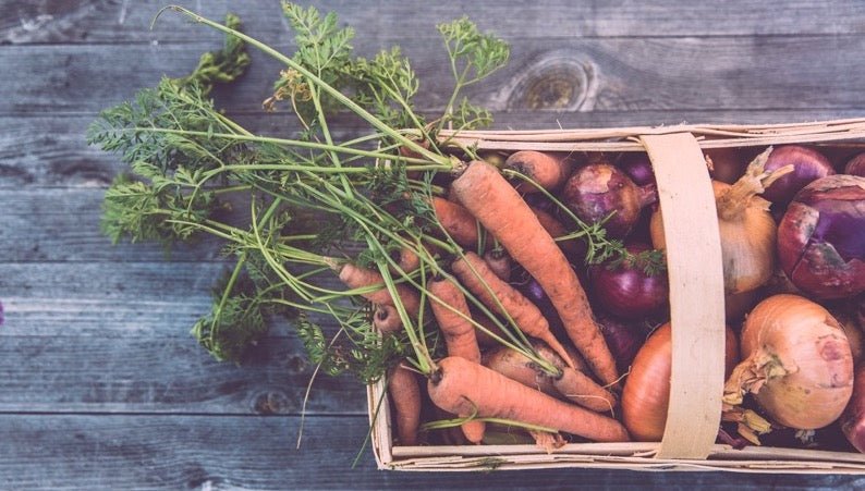 Carrots in basket with onions