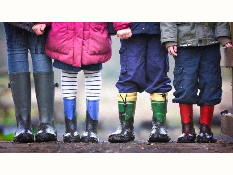 Row of children wearing muddy gumboots
