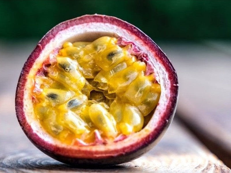 Passionfruit cut in half on wooden bench