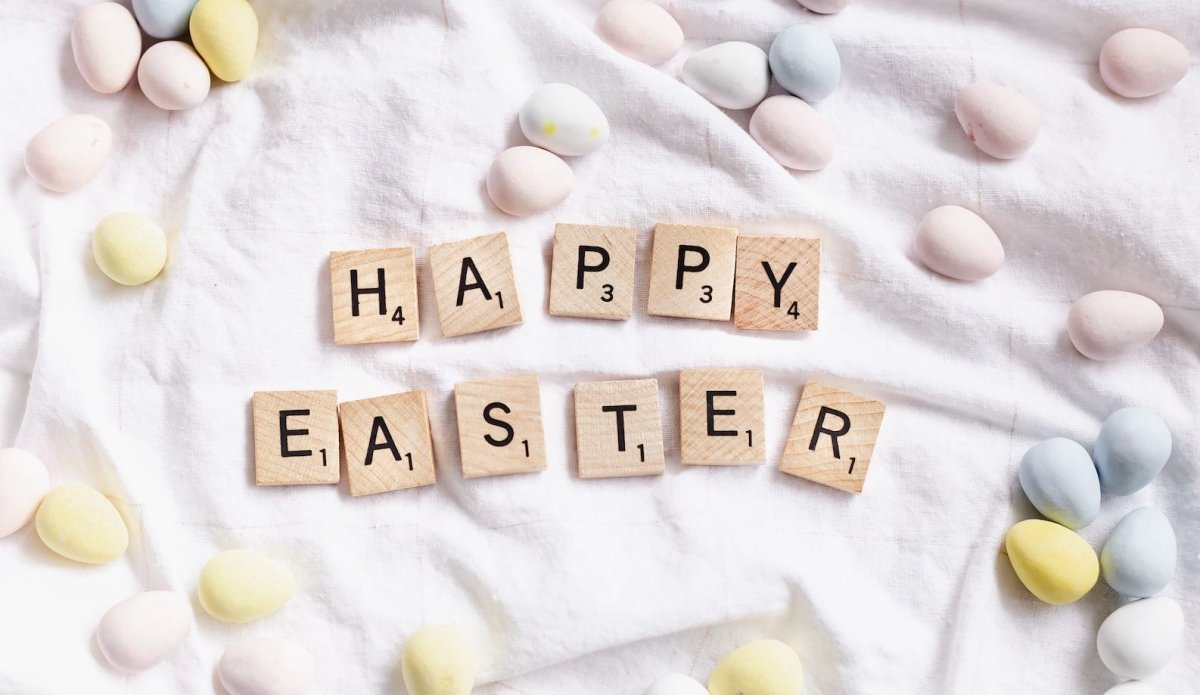 Happy Easter in wooden scrabble tiles on fabric with small eggs
