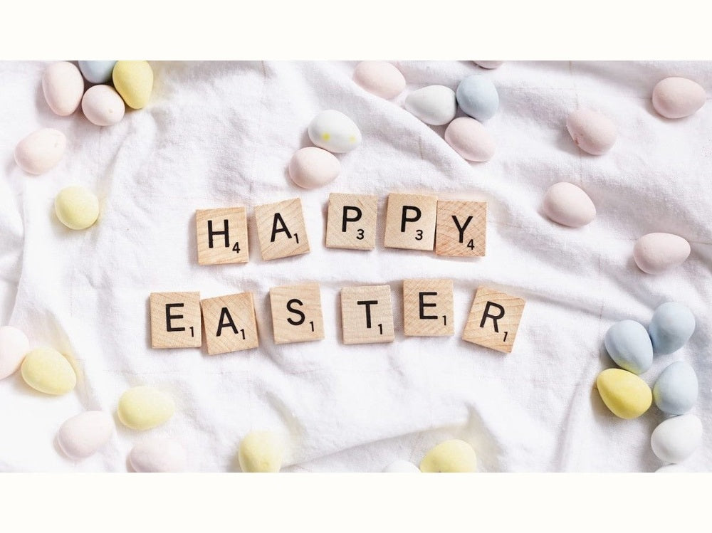 Happy Easter in wooden scrabble tiles on fabric with small eggs