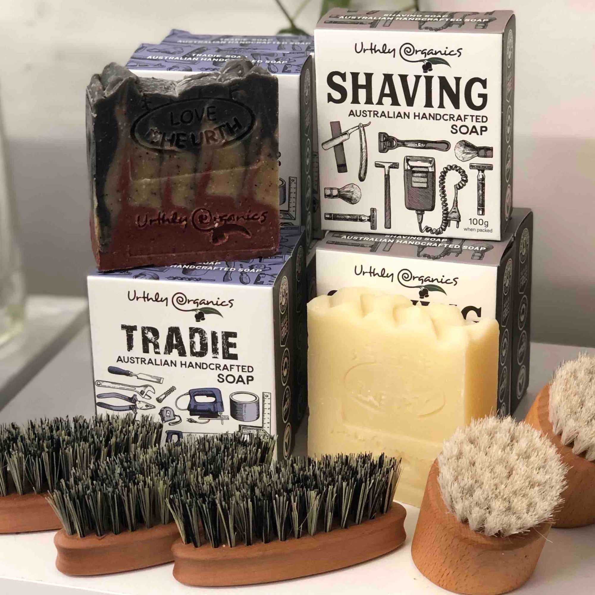 Bars of tradie soap and shaving soap behind beard brushes