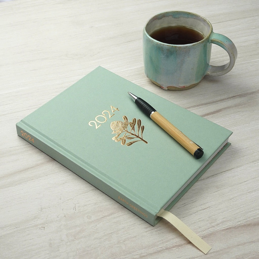 Earth Greetings 2024 Eucalyptus Diary with Bamboo Pen and Cup of Coffee.