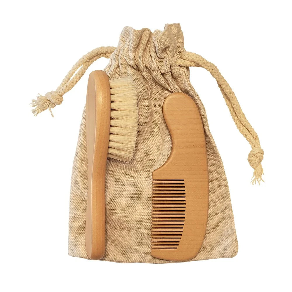 Wooden handled soft baby hairbrush and matching comb set, on top of a linen drawstring bag.