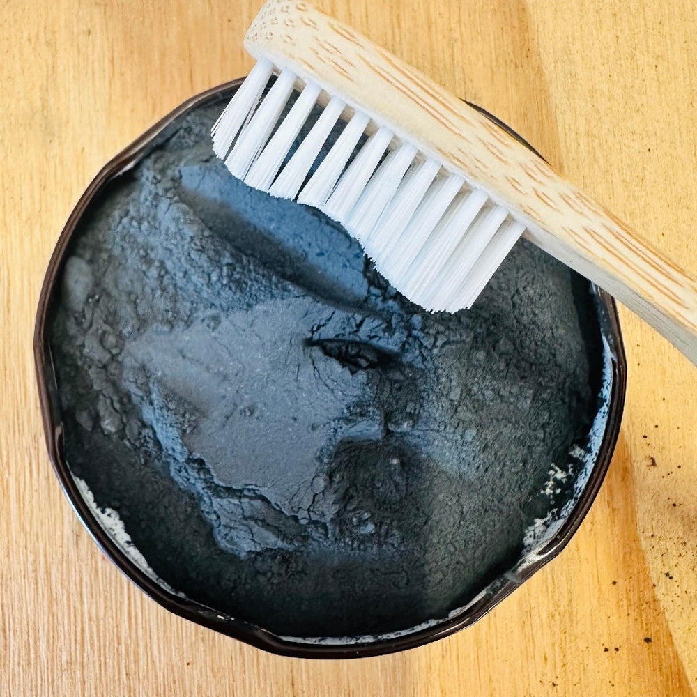 Toothbrush Dipping in Charcoal Tooth Powder from The Family Hub.