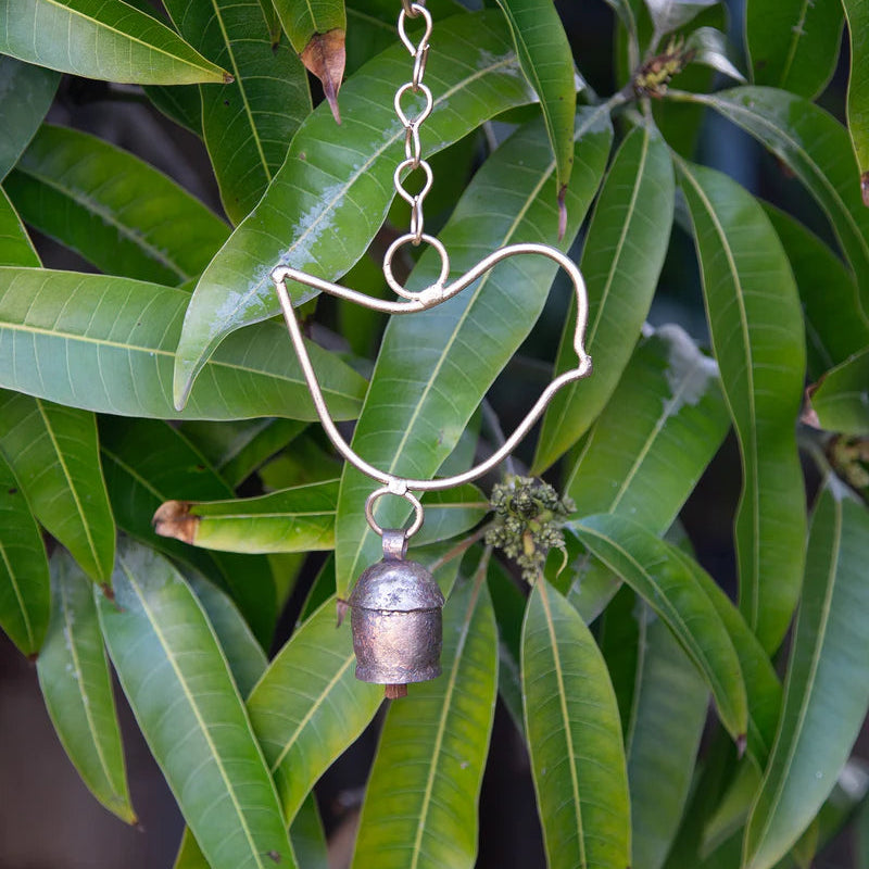 Fair Trade Handmade Decorative Bell Chime with Single Bird Design against Leafy Backdrop.