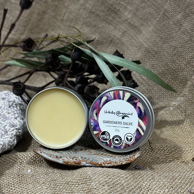 An open round tin of gthe ardeners salve showing pale yellow balm inside and the closed tin with label.