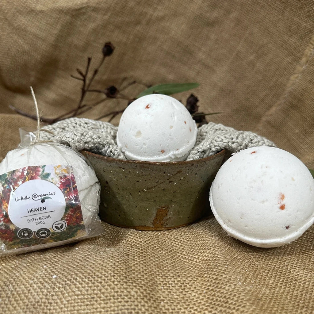 Three Heaven bath bombs from Urthly Organics, one with a floral label, and two unwrapped.