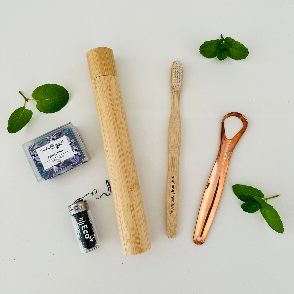 Oral Care Kit with Bamboo Toothbrush, Bamboo Toothbrush Case, Copper Tongue Cleaner, Charcoal Bamboo Floss in Glass Container, Peppermint Toothsoap in Case. 