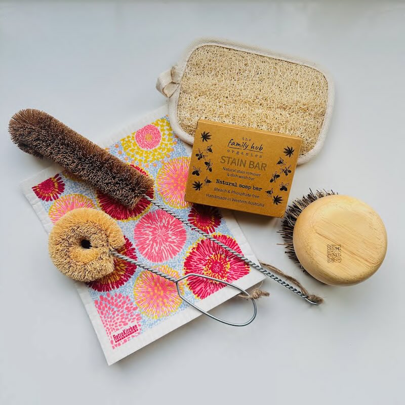 Set of kitchen cleaning tools including a loufah wash pad, a pan scrubbing brush, a dish wash soap bar, a bottle brush, a dish wash cloth and a dish wash brush.