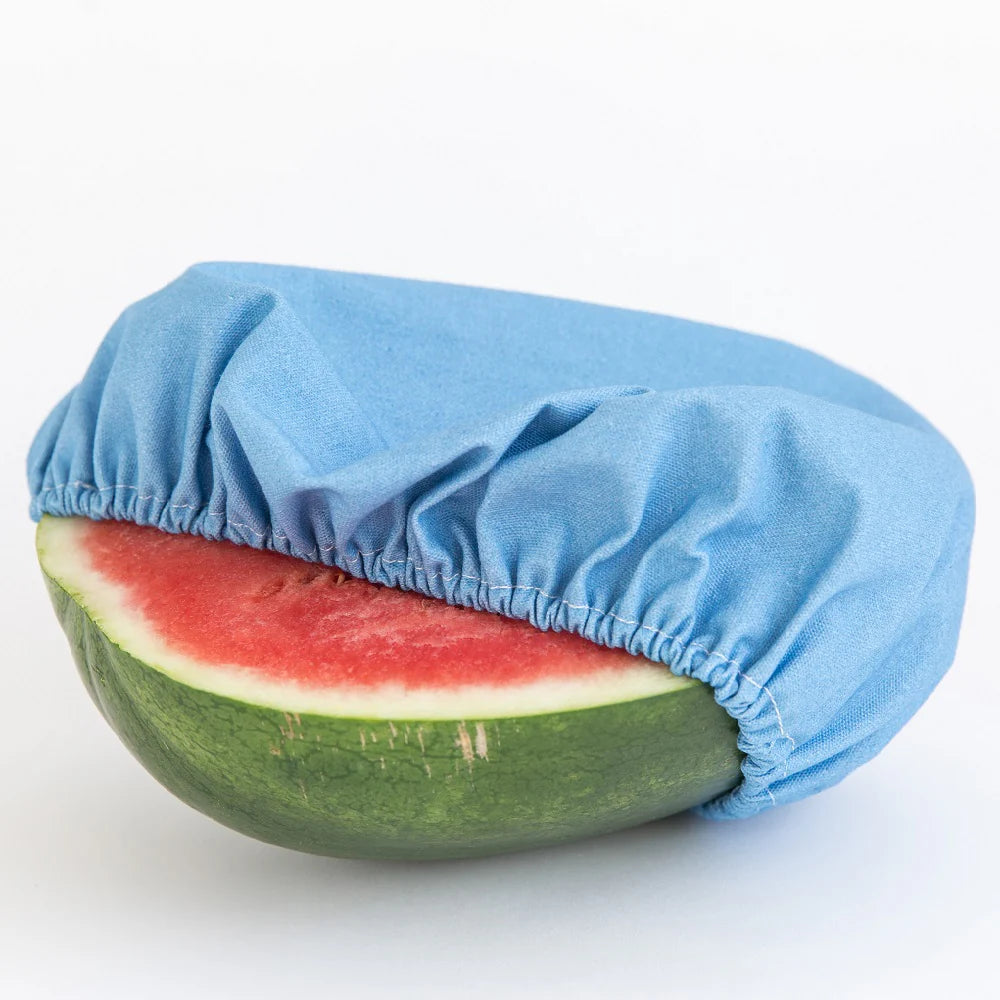 Half of large cut watermelon covered with with Denim coloured cotton canvas food cover
