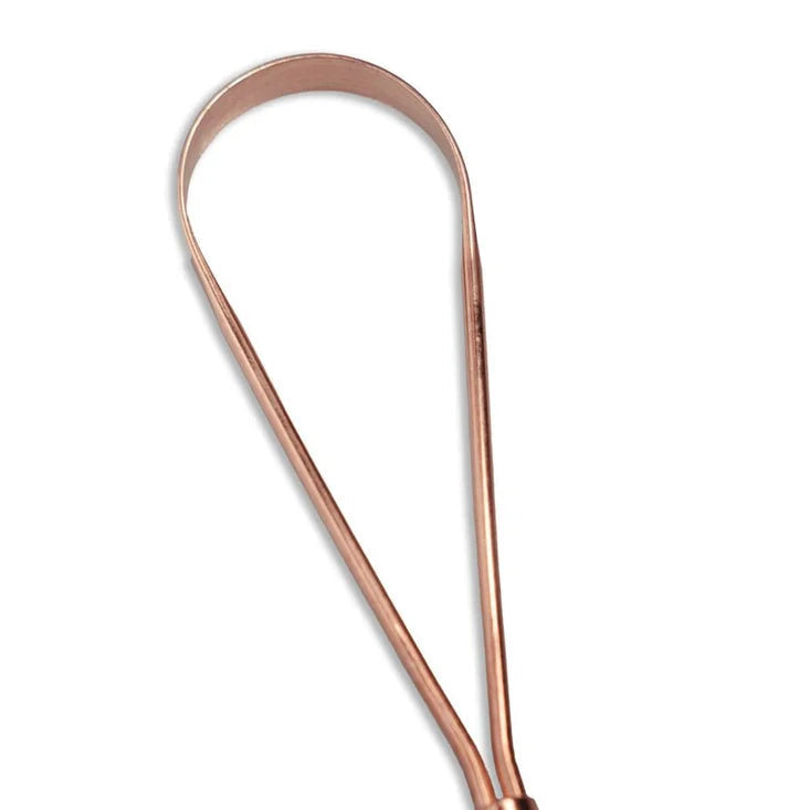 Close up of the loop of a copper tongue scraper tool, shown on a plain white background.