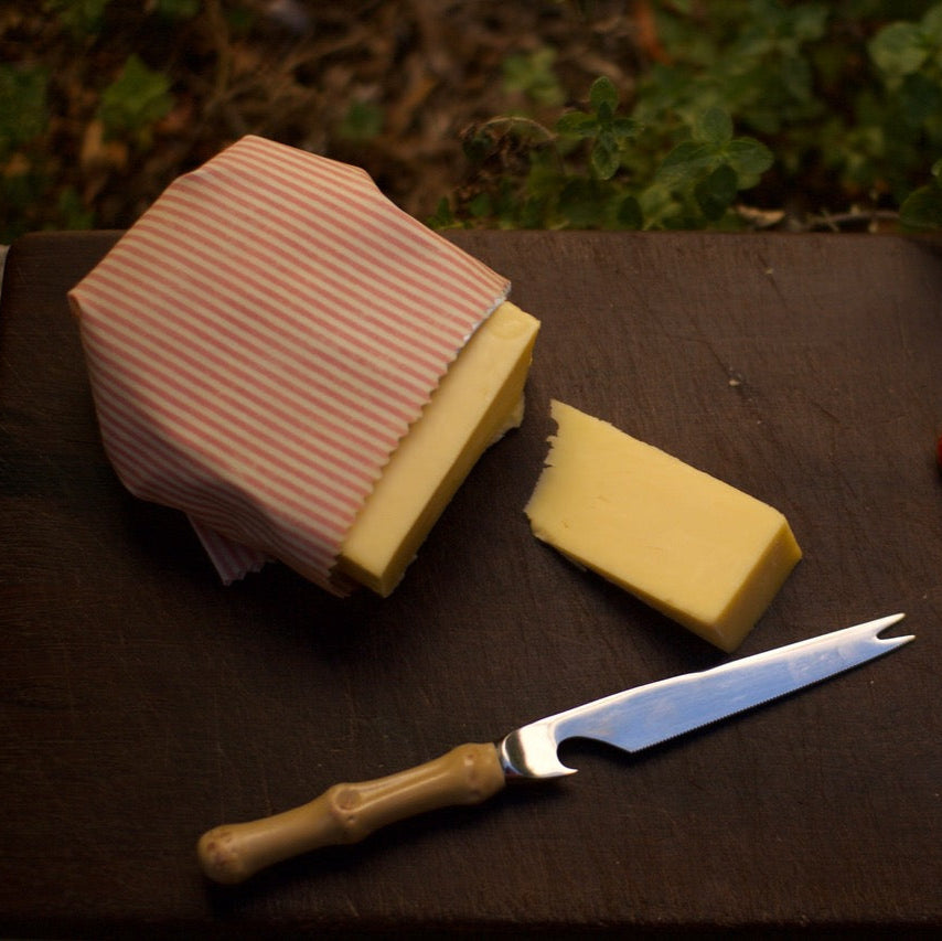 Block of Cheese on Board Wrapped in Beeswax Wrap.