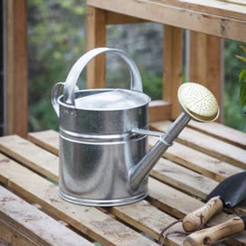 Galvanised Watering Can (5L) from Garden Trading, on Wooden Bench With Hand Trowel