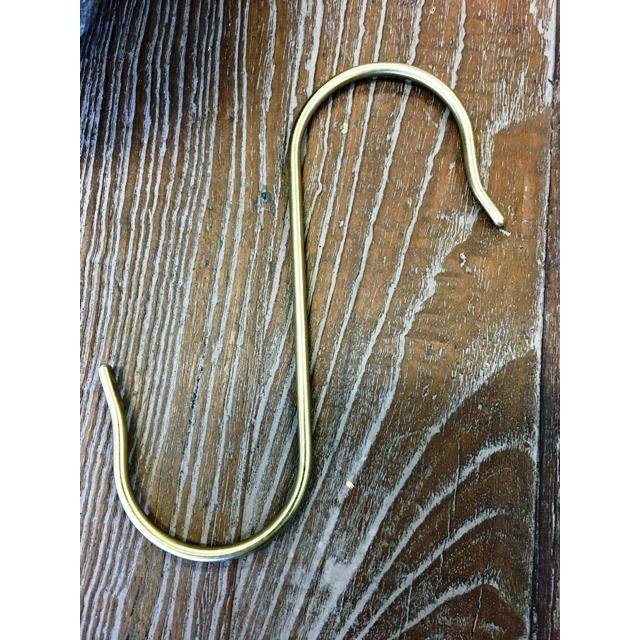 Large Brass S Hook from Heaven In Earth, on Wooden Background