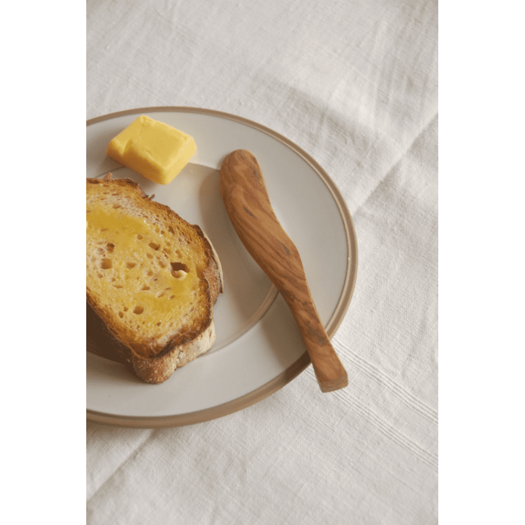 The Olive Wood Butter Knife from Heaven In Earth, on a Plate with Toast and Butter