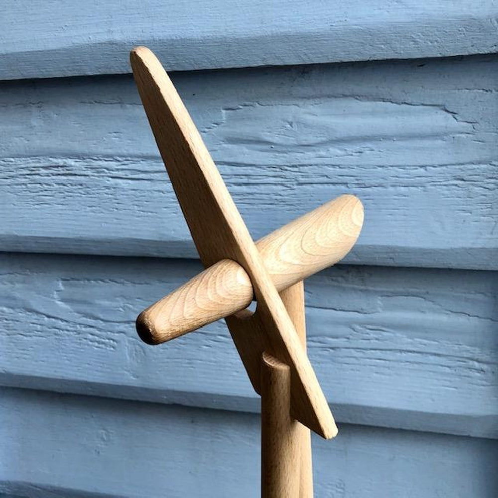 Handles of the Redecker Dust Pan and Brush Set Against a Blue Wall