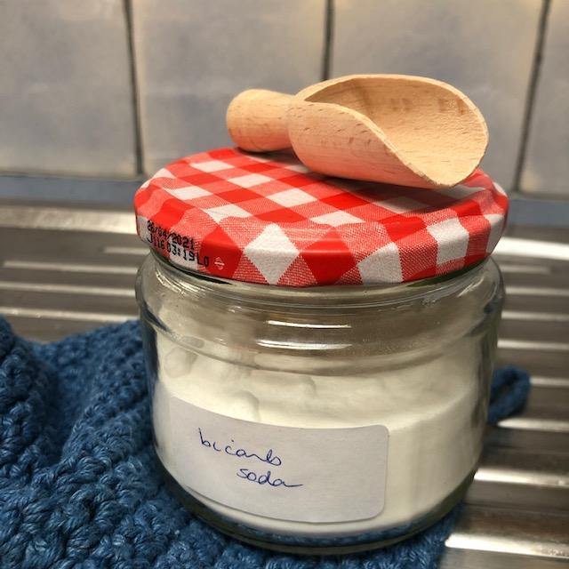 A Refillable Jar of Bicarbonate Soda, with Knitted Cloth and Wooden Scoop