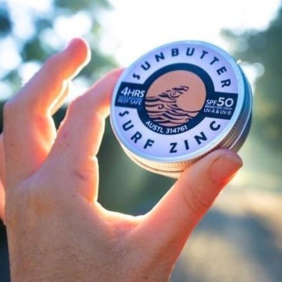 Sunbutter vegan surf zinc held in a white hand